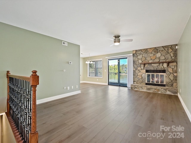 unfurnished living room featuring ceiling fan, a fireplace, and hardwood / wood-style floors