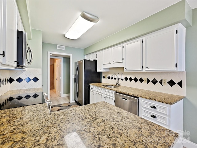 kitchen featuring sink, white cabinets, light hardwood / wood-style flooring, appliances with stainless steel finishes, and light stone countertops