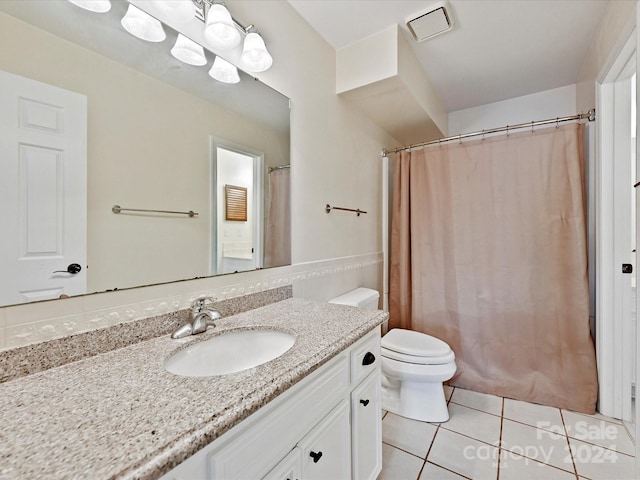 bathroom featuring a shower with shower curtain, vanity, toilet, and tile patterned floors