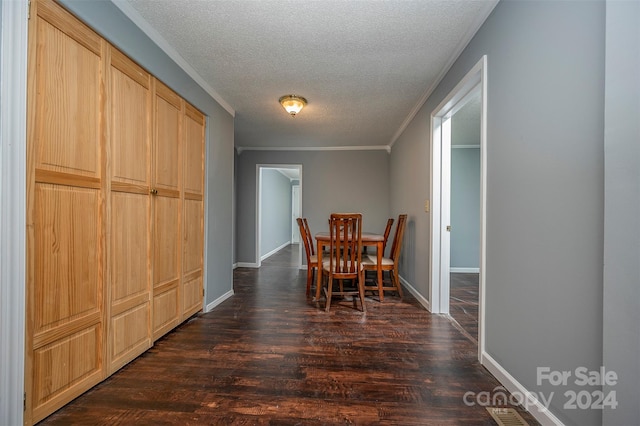 dining room featuring dark hardwood / wood-style flooring, crown molding, and a textured ceiling