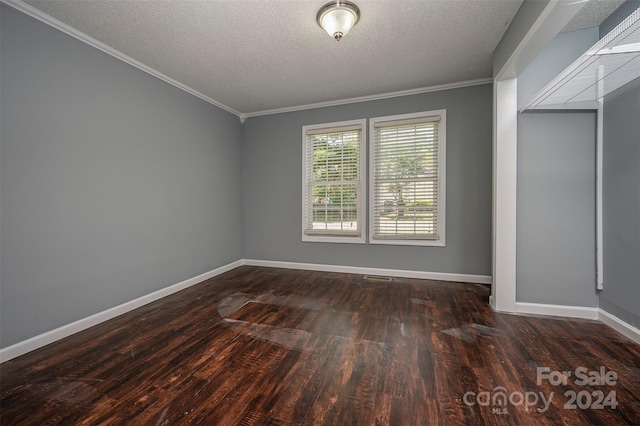 empty room with a textured ceiling, crown molding, and dark hardwood / wood-style floors