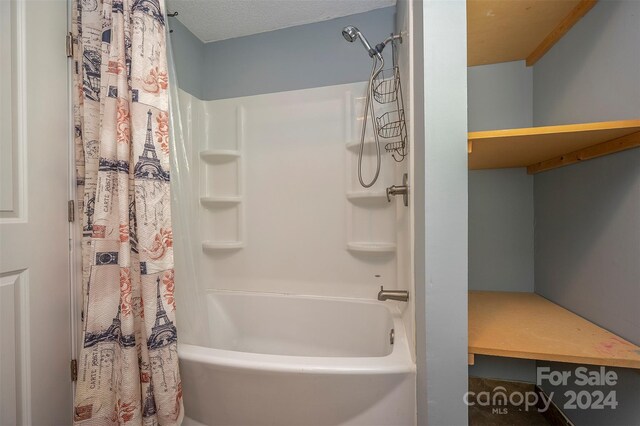 bathroom with a textured ceiling and shower / bath combo