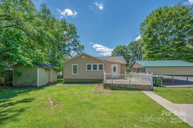 exterior space with an outbuilding, a front yard, and a carport