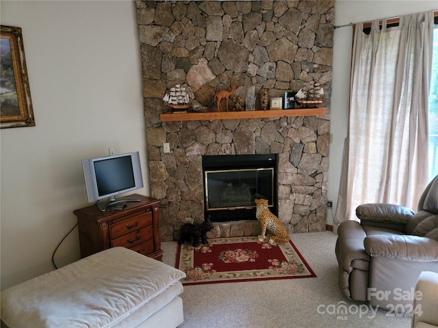 living room with carpet flooring and a stone fireplace