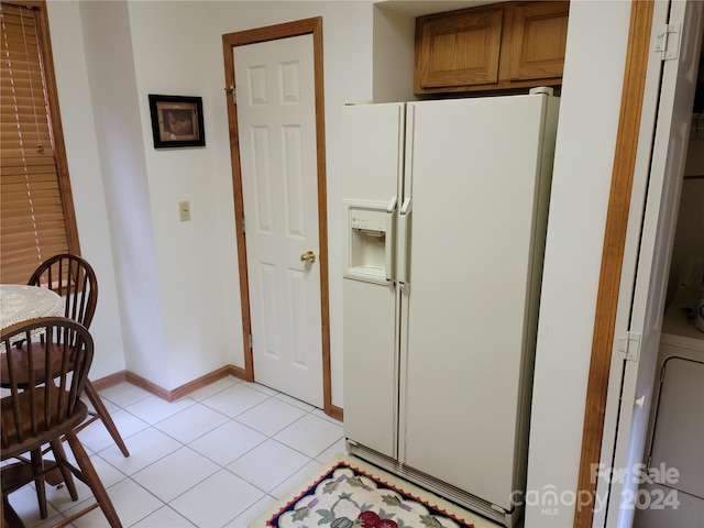 kitchen featuring light tile patterned floors and white fridge with ice dispenser