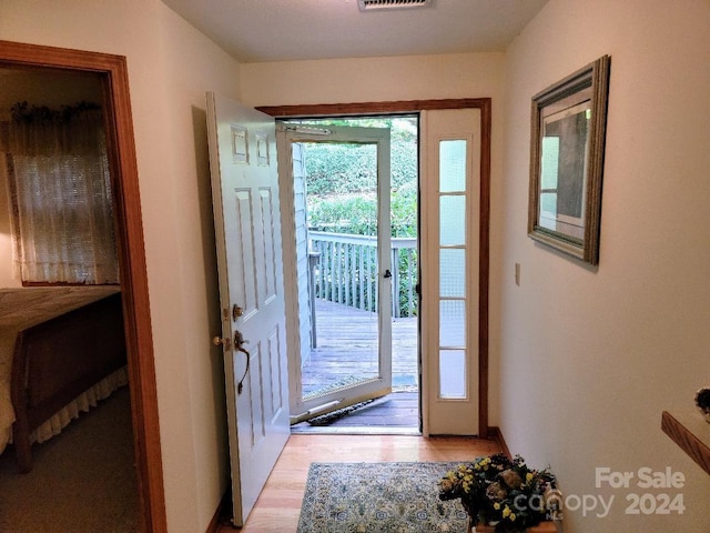 doorway with a wealth of natural light and light hardwood / wood-style flooring