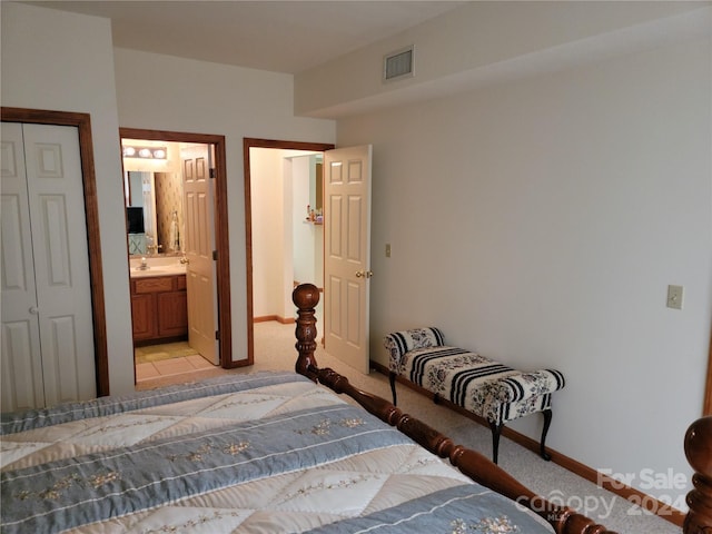 carpeted bedroom featuring ensuite bathroom and a closet