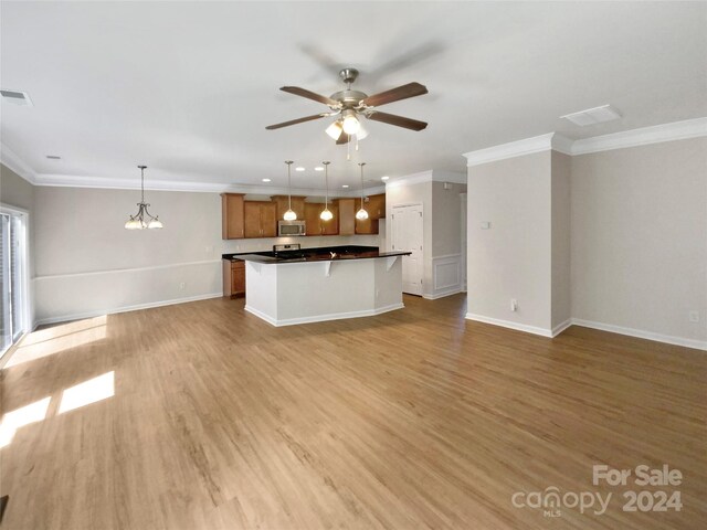 unfurnished living room featuring ceiling fan with notable chandelier, crown molding, and light hardwood / wood-style floors