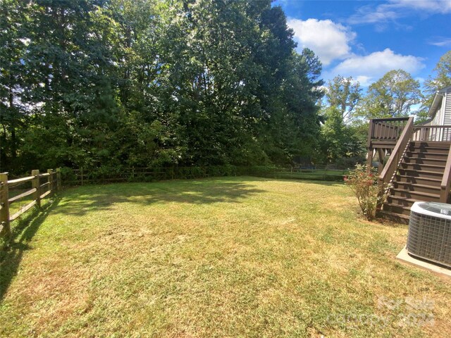 view of yard with cooling unit and a deck