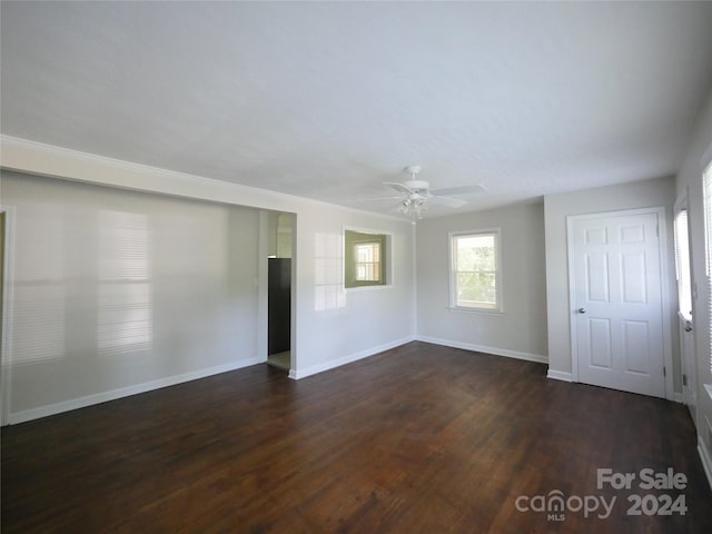 empty room with ceiling fan and dark hardwood / wood-style flooring