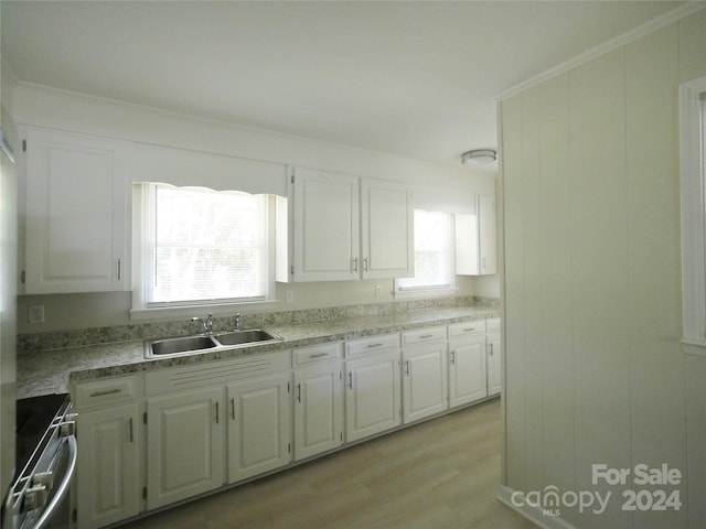 kitchen featuring a wealth of natural light, electric stove, and white cabinets