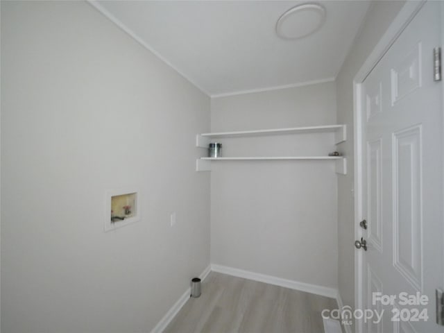 laundry area featuring light wood-type flooring, crown molding, and washer hookup