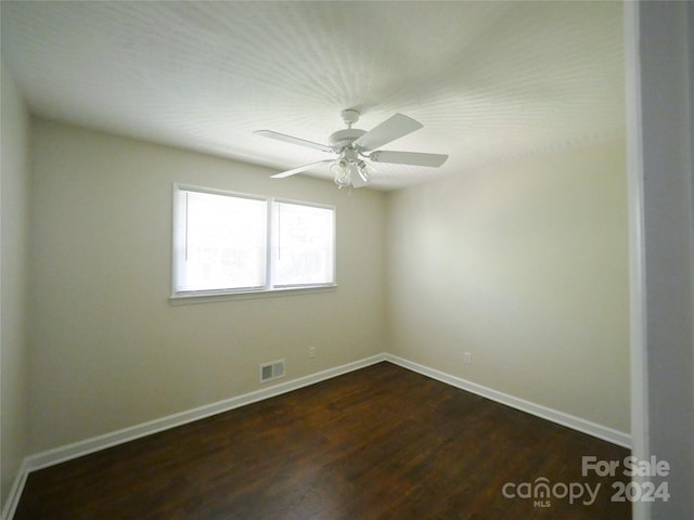 spare room with ceiling fan and dark hardwood / wood-style flooring