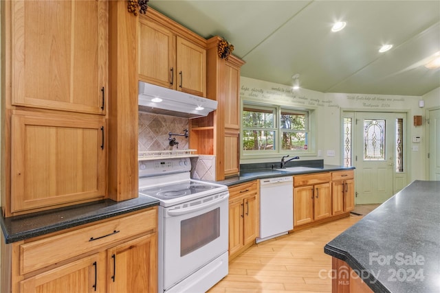 kitchen featuring white appliances, light hardwood / wood-style floors, tasteful backsplash, and sink