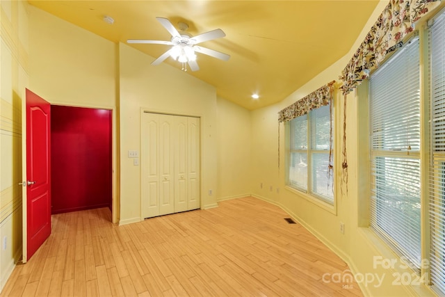 spare room featuring vaulted ceiling, baseboards, ceiling fan, visible vents, and wood finished floors