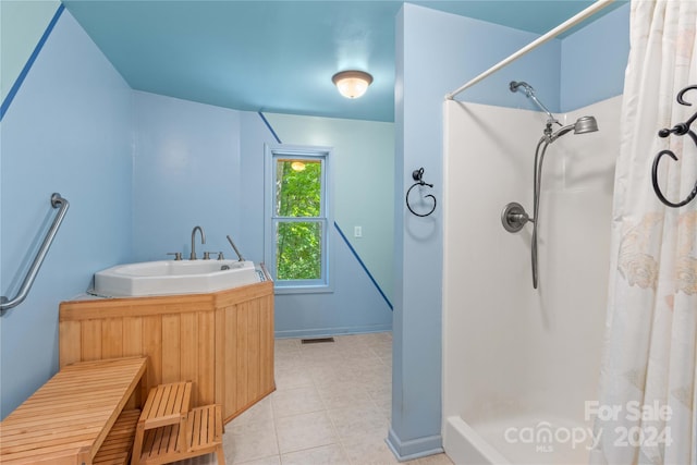 full bathroom featuring tile patterned flooring, baseboards, a shower with shower curtain, a sink, and visible vents