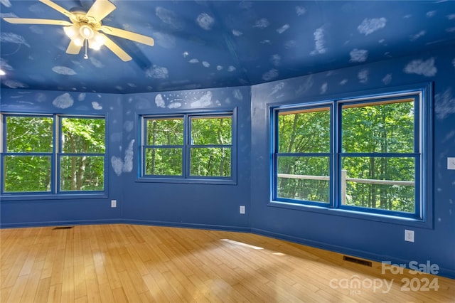 empty room with a ceiling fan, wood finished floors, and visible vents