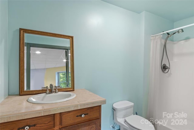full bath with a shower with curtain, toilet, and vanity