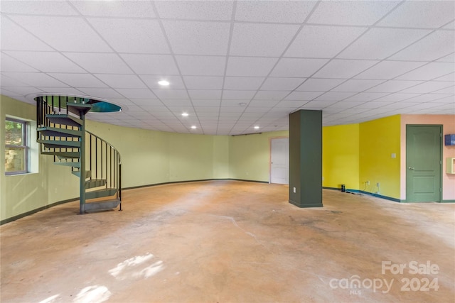 basement featuring baseboards, stairs, recessed lighting, and a drop ceiling