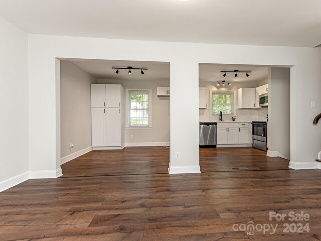 unfurnished living room featuring dark hardwood / wood-style flooring and a healthy amount of sunlight