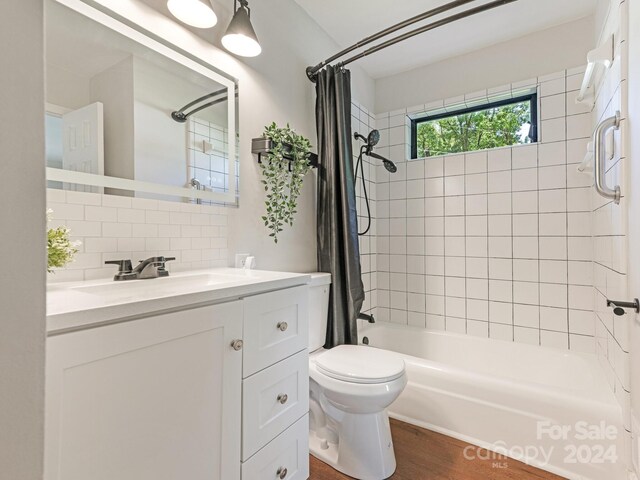 full bathroom featuring backsplash, toilet, wood-type flooring, shower / bath combo with shower curtain, and vanity