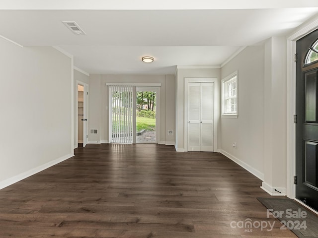 spare room featuring ornamental molding and dark hardwood / wood-style flooring