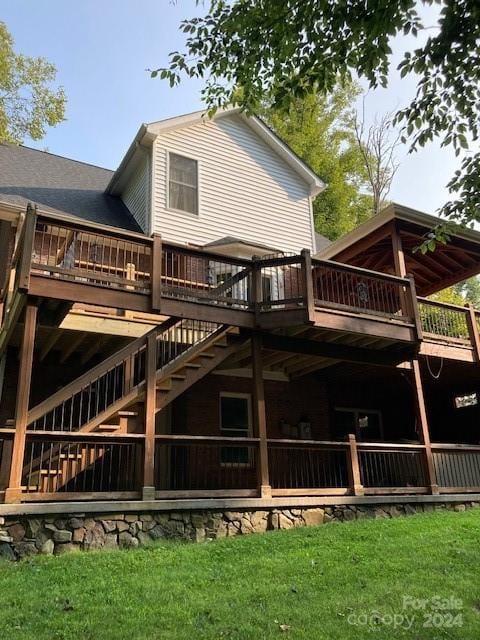 back of property featuring a lawn and a wooden deck