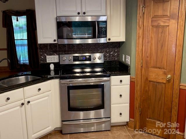 kitchen with sink, appliances with stainless steel finishes, white cabinets, and tasteful backsplash