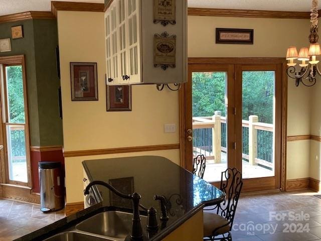 interior space with a chandelier, crown molding, and sink