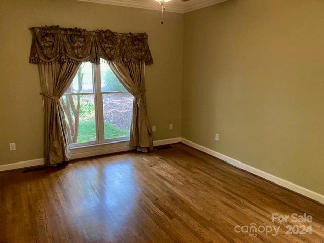 unfurnished room with hardwood / wood-style floors and crown molding