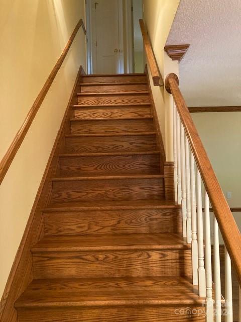 staircase with a textured ceiling