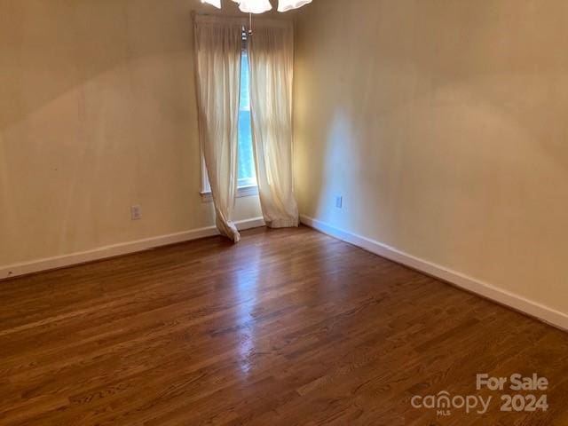 empty room with dark hardwood / wood-style flooring