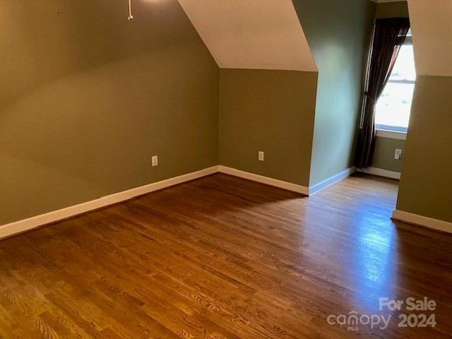 additional living space with lofted ceiling and hardwood / wood-style floors