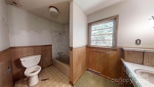 bathroom with ornamental molding, vanity, toilet, and wood walls