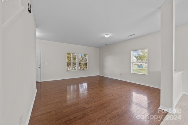 unfurnished room with a wealth of natural light and dark hardwood / wood-style flooring