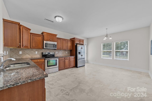 kitchen featuring an inviting chandelier, hanging light fixtures, stainless steel appliances, sink, and decorative backsplash