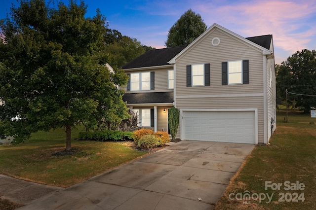 front of property featuring a garage and a yard