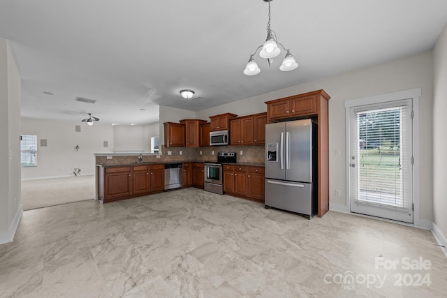 kitchen with light carpet, decorative light fixtures, kitchen peninsula, decorative backsplash, and appliances with stainless steel finishes