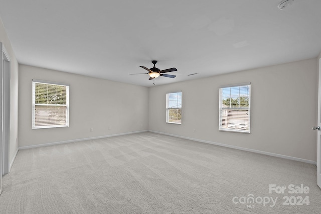 unfurnished room featuring light colored carpet and ceiling fan