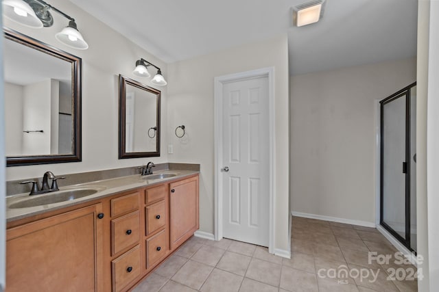 bathroom with tile patterned flooring, a shower with door, and vanity