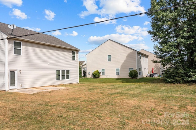 back of house with a yard and a patio