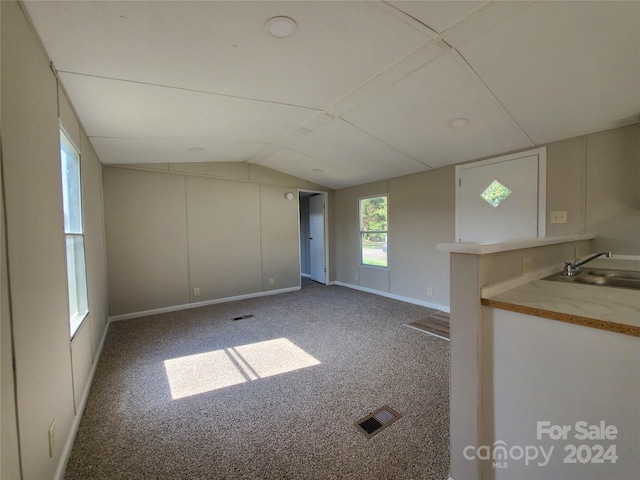 carpeted empty room featuring lofted ceiling and sink