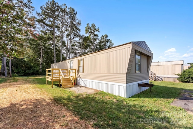 view of side of home with a yard and a wooden deck