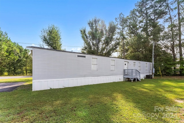 exterior space featuring cooling unit and a yard