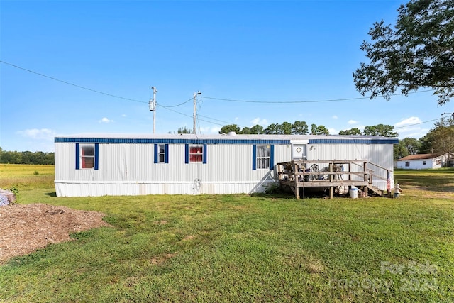 back of property with a yard and a deck