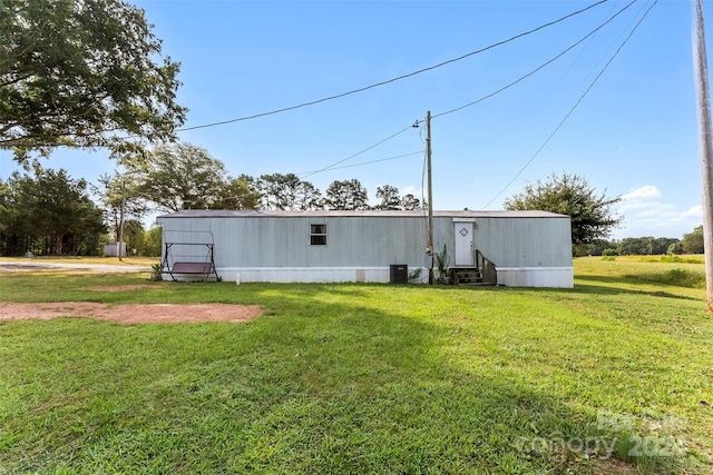 rear view of house with central AC, a yard, and an outdoor structure