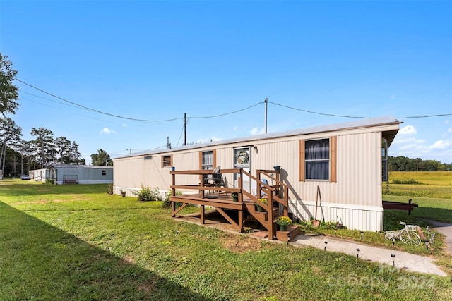 rear view of house with a yard and a deck