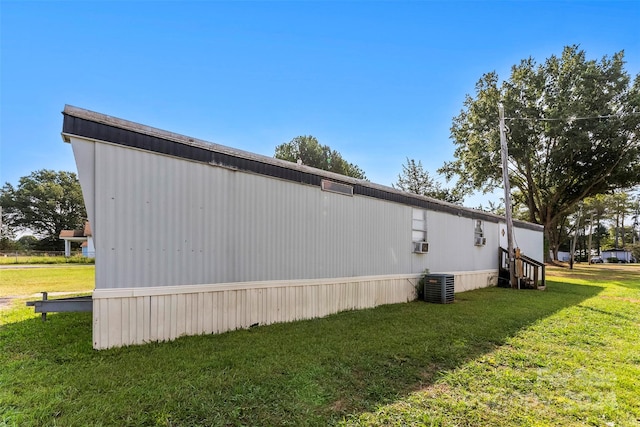 view of side of property with a yard and central air condition unit