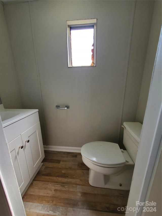 bathroom with vanity, toilet, and wood-type flooring