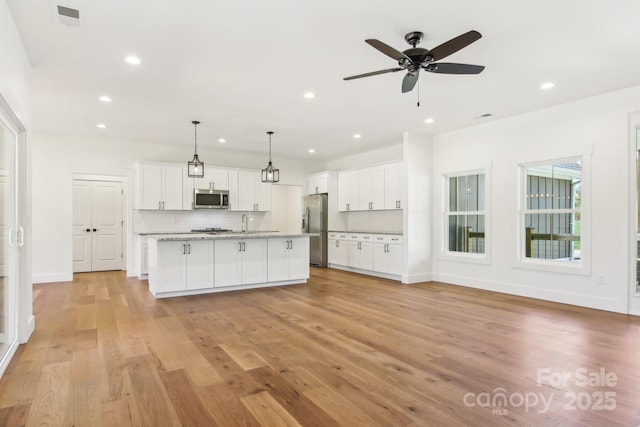 40 Haywood Park Dr, Hendersonville, NC 28791 - kitchen featuring appliances with stainless steel finishes, a ceiling fan, white cabinets, light wood-style flooring, and decorative backsplash